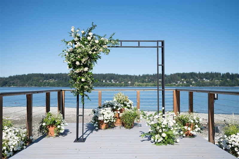 wedding ceremony arbor decorated white white flowers and greenery