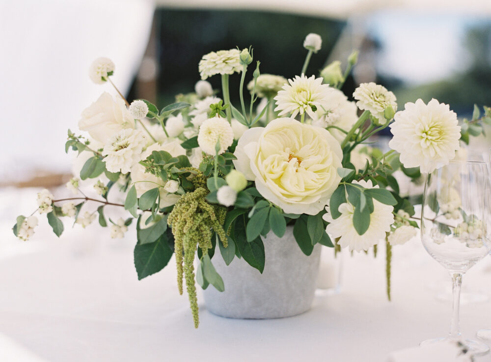 Wedding reception centerpieces made with white garden roses, dahlias, snowberry and other summer flowers
